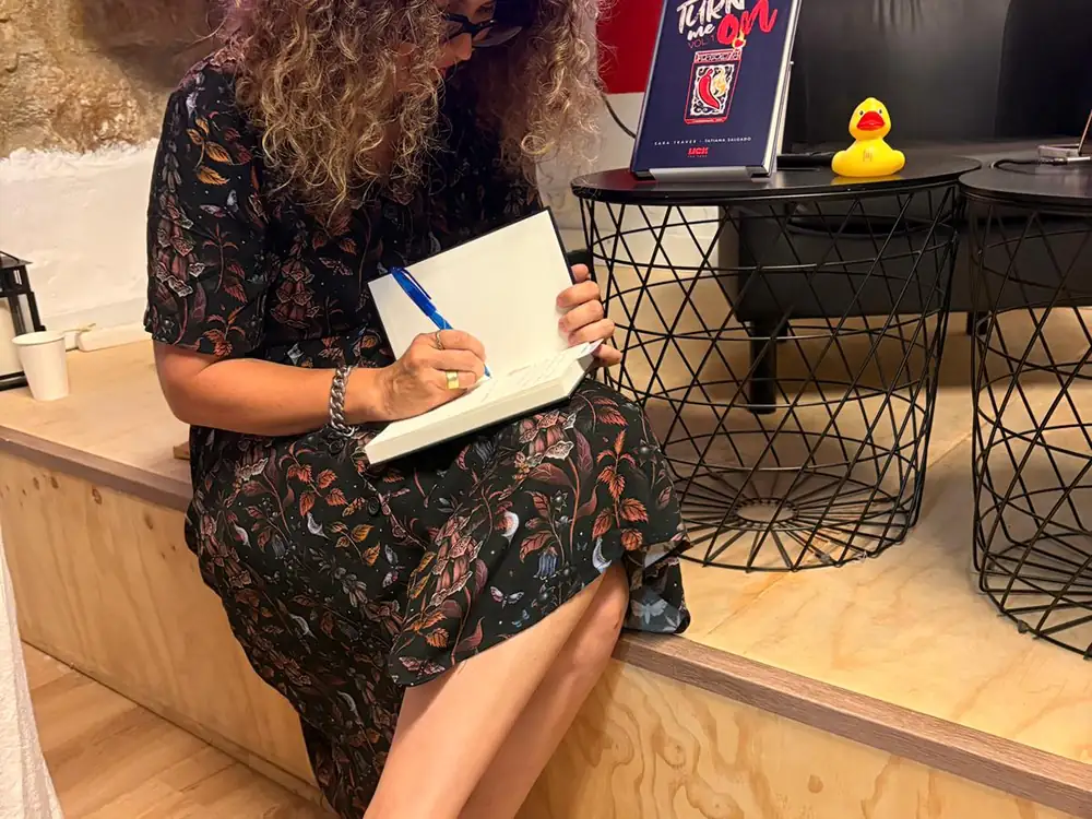 Firmando ejemplares de Turn me on en una presentación
